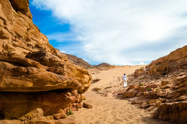 Muž v bílém arabském oblečení chodí v barevném kaňonu v Egyptě Da — Stock fotografie