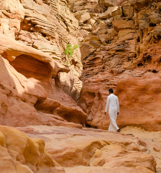 Чоловік у білому арабовому одязі ходить у кольоровому каньйоні в Єгипті Да. — стокове фото