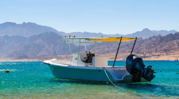 Barco a motor en el mar contra la costa con alta montaña rocosa — Foto de Stock