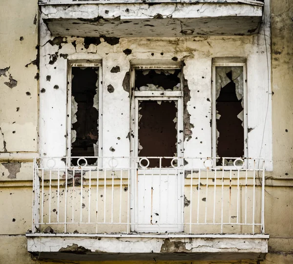 Förstört hus med spår av kulor i väggarna i kriget i — Stockfoto