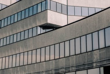 pencerelerde gökyüzü ve bulutların yansıması ile yüksek beton bina