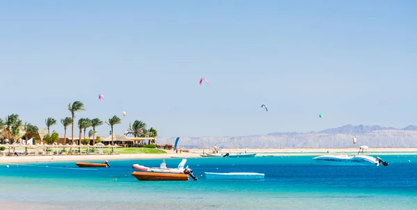 Hotel con palmeras en el Mar Rojo en Egipto Dahab con barcos y cometas surfistas — Foto de Stock