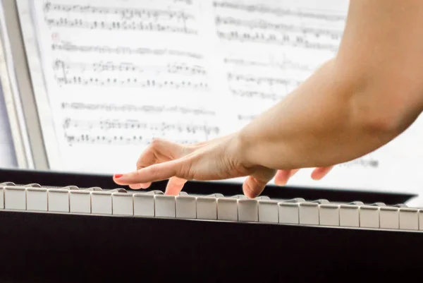 Mãos femininas de um músico pianista e teclas de piano de perto — Fotografia de Stock