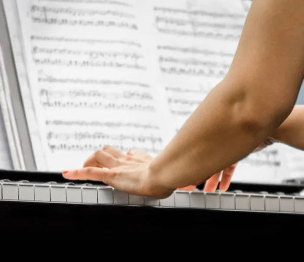 Mãos femininas de um músico pianista e teclas de piano de perto — Fotografia de Stock