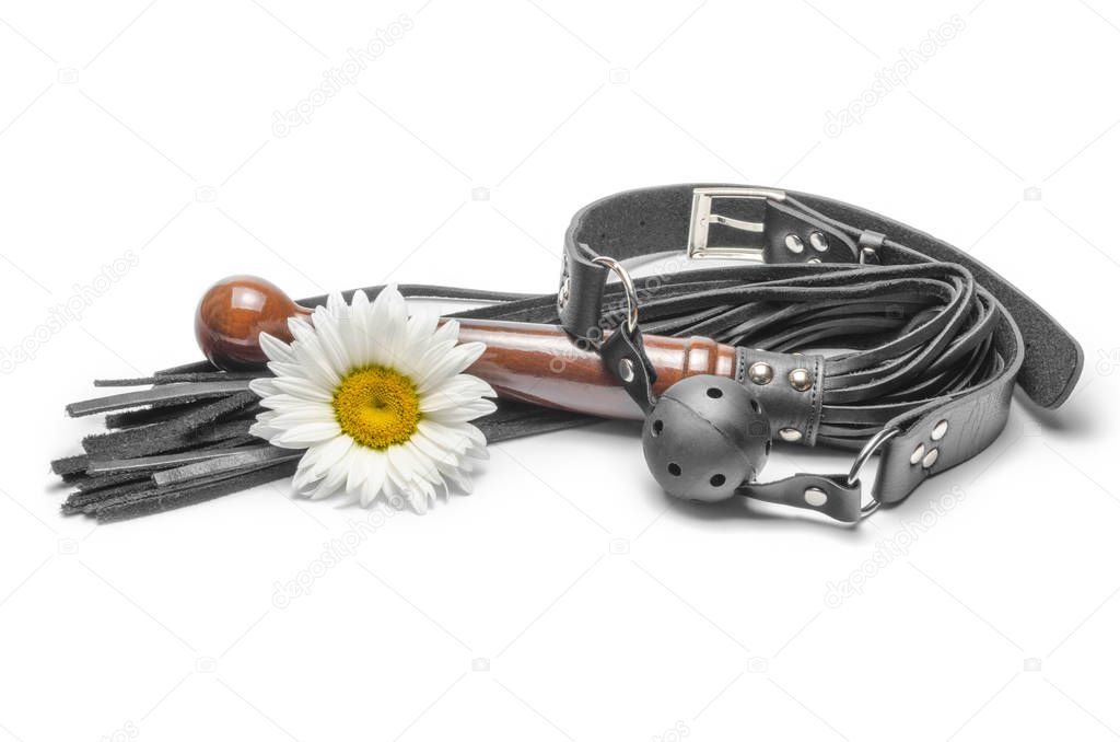 bdsm black leather lash with gag and yellow daisy flower on a white background
