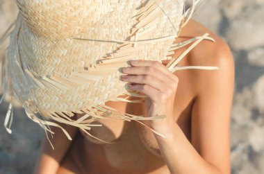 bir saman şapka genç kız plajda kumlu oturur yakın yukarı