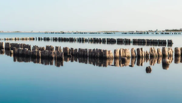 Colonnes en bois dans une surface calme de l'eau — Photo