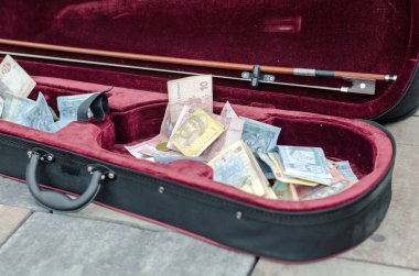 ukrainian money bills in a case of a street musician  clipart
