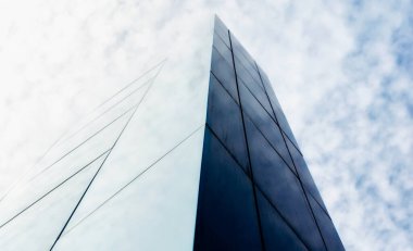 Gökyüzüne karşı modern bir bina duvarı ve soyut mimari arka plan bulutları