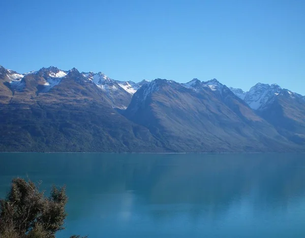 Las Montañas Cubiertas Nieve Bordean Lago Azul Oscuro Cielo Azul — Foto de Stock