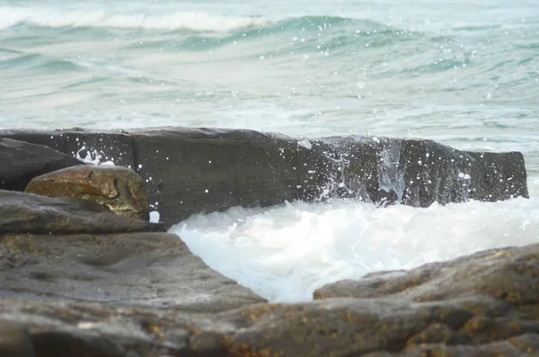 海浪从岩石上拍打的白色泡沫正在喷向空气中 其他的波浪在远处破浪 — 图库照片