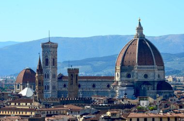 Bir ortaçağ kalesi bir tepenin yamacında oturur. Örüntüsünde tilled alanları ve orman tarafından çevrilidir. Gökyüzü beyaz bulutlar mavidir.