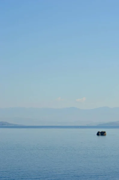 Dağlarla çevrili bir koyda küçük bir ada. — Stok fotoğraf