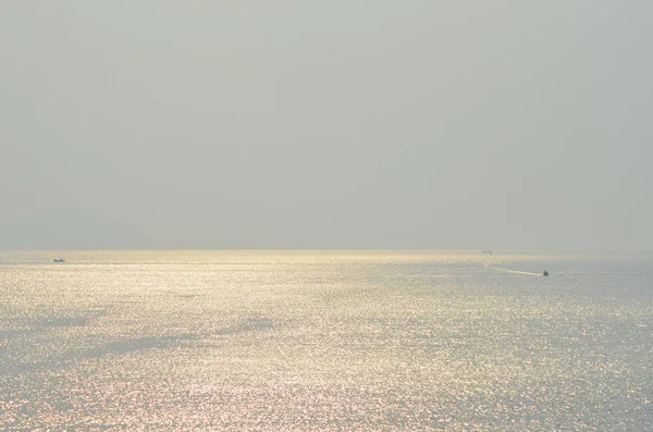 Sisli bir gökyüzünün altında, bazı teknelerle altın bir okyanus.. — Stok fotoğraf