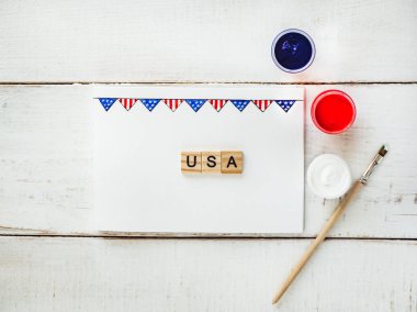 ABD bayrağı, word ABD ve renkli guaş bir desen kartıyla beyaz, vintage, ahşap bir masaya boyar. Üstten görünüm, yakın çekim. Bir bağımsız, güçlü bir ülke ve ulus kavramı