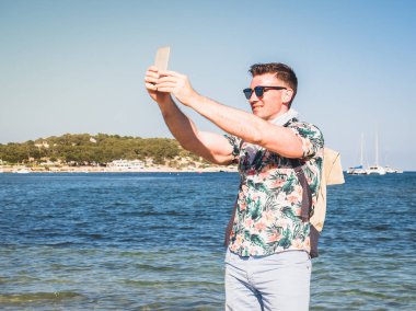 Bir sırt çantası ile mutlu, gülümseyen adam