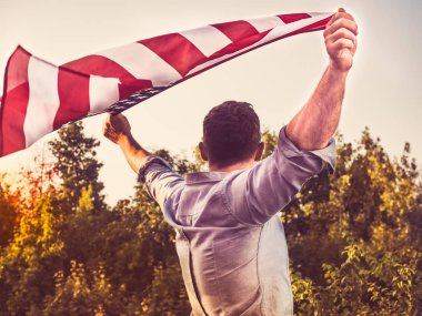 Çekici bir adam bizi bayrak tutan. Tatil için hazırlanıyor