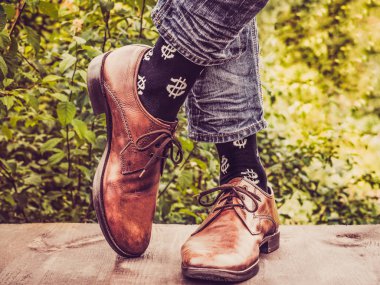 Erkekler bacaklar şık ayakkabı, siyah çorap bize dolar arka planı yeşil ağaçlar ahşap Teras şeklinde desenleri ile. Güzellik, moda, zerafet