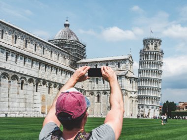 Pisa Kulesi üzerinde güneşli, fotoğrafını çekmek bir telefon ile şık adam gün temizleyin. Kavramı rekreasyon, seyahat ve Turizm
