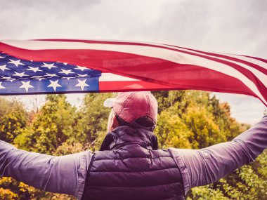 Çekici bir adam bir beyzbol şapkalı bir ABD bayrağı holding