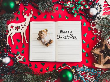 Renkli Noel süsleri, gümüş boncuklar, Noel ağacın, kırmızı bir yüzey üzerinde çok renkli gelin teli. Üstten görünüm, yakın çekim, düz yatıyordu. Tebrik kartı