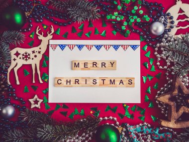 Renkli Noel dekorasyonu, gümüş boncuklar, Noel ağaç dalları, çizim ve defter kırmızı bir yüzey üzerinde yazıt. Üstten görünüm, yakın çekim, düz yatıyordu. Tebrik kartı