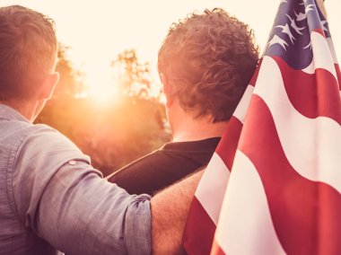 Two cute guys holding the US flag clipart