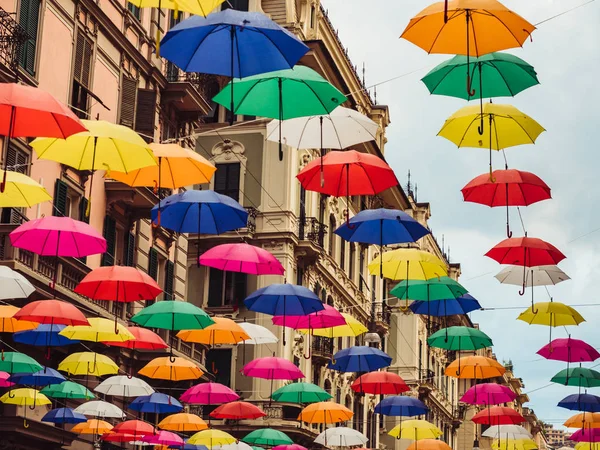 Multicolored and bright umbrellas hanging between houses — Stock Photo, Image