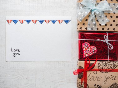 Ahşap beyaz tahtalar üzerinde sevgi ve parlak hediye kutuları hakkında tatlı sözler için boş Not Defteri sayfası. Portre, düz yatıyordu. Sevdiklerimiz, akrabalar, arkadaşlar, iş arkadaşları için tebrikler