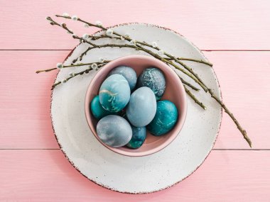 Paskalya yumurtaları pembe bir arka plan üzerinde parlak renklerde boyanmış