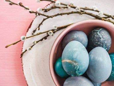 Paskalya yumurtaları pembe bir arka plan üzerinde parlak renklerde boyanmış