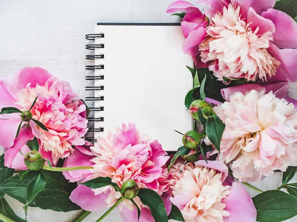 Pivoines lumineuses, page de bloc-notes vierge sur une table en bois — Photo