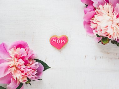 Parlak çiçek ve pembe, beyaz, izole bir arka plan üzerinde kelime anne ile sırlı tanımlama bilgisi. Üstten Görünüm, yakın çekim. Mutlu aile kavramı