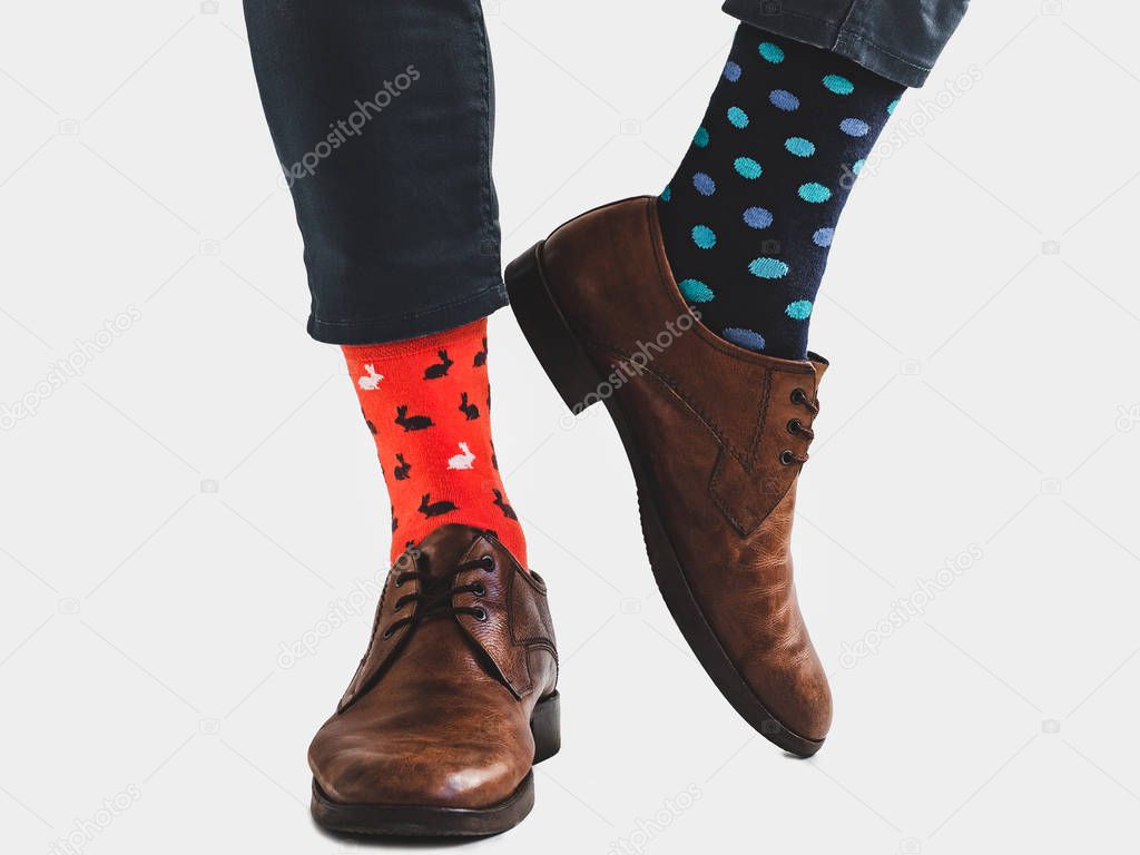 Office Manager in stylish shoes, blue pants and bright, colorful socks on a white, isolated background. Close-up. Style, fashion, fun, elegance