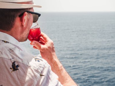 Elinde güzel bir kadeh pembe şarap tutan adam