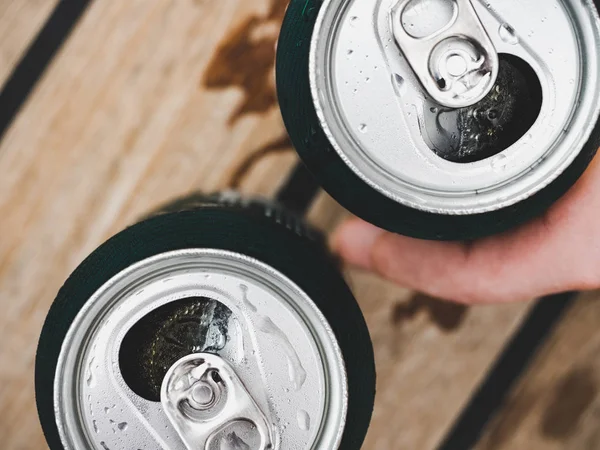 Two can of beer, female and male hands