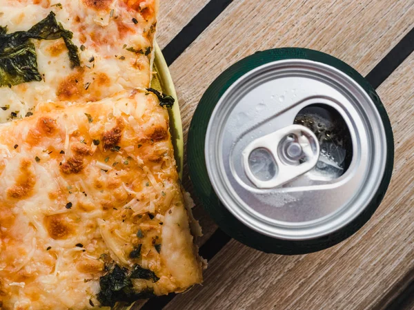 Can of beer and a piece of pizza. Top view