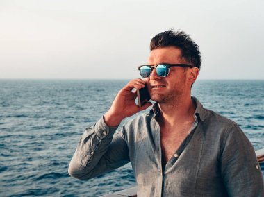 Adam boş güvertede bir cep telefonu tutan
