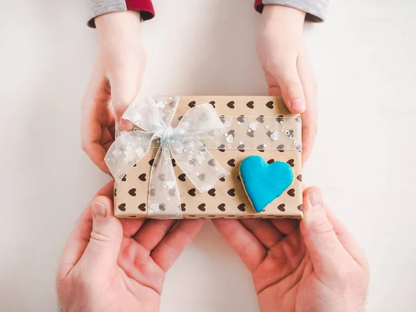 Manos de niño y una hermosa caja de regalo — Foto de Stock