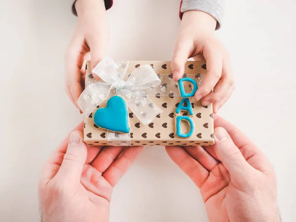 Manos de niño y una hermosa caja de regalo — Foto de Stock