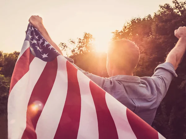 Yakışıklı, genç adam Amerikan bayrağı sallıyor