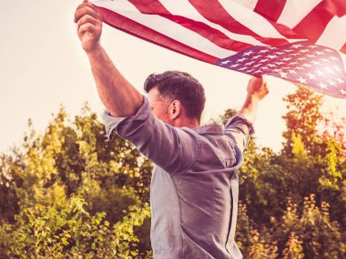 Yakışıklı, genç adam Amerikan bayrağı sallıyor