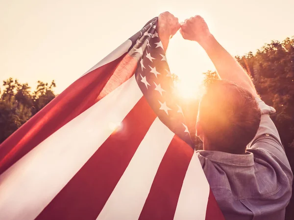 Красивый молодой человек, размахивающий американским флагом — стоковое фото