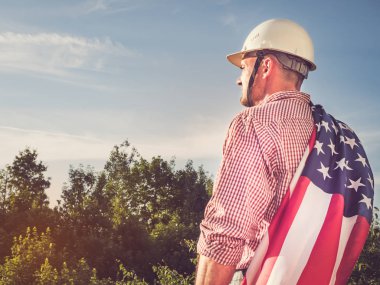 Genç mühendis, beyaz şapka ve Amerikan Bayrağı.