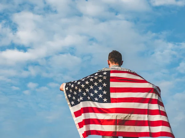 Красивый молодой человек, размахивающий американским флагом — стоковое фото