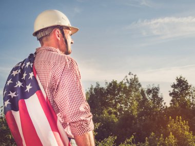 Genç mühendis, beyaz şapka ve Amerikan Bayrağı.