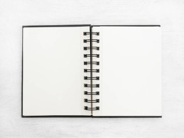 Beyaz bir masanın üzerinde duran boş bir defter.