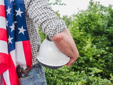 Aletleri olan yakışıklı bir adam, elinde Amerikan bayrağı var. Arkadan bak, yakın plan. İş ve istihdam kavramı