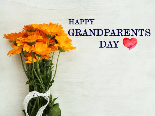 全国祖父母日 美丽而明亮的花朵躺在一张白色的木制桌子上 从上面看 — 图库照片