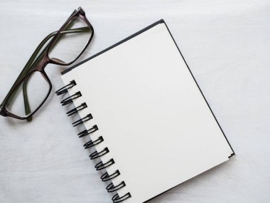 Boş not defteri sayfası, kalem ve gözlük. Tebrik kartı